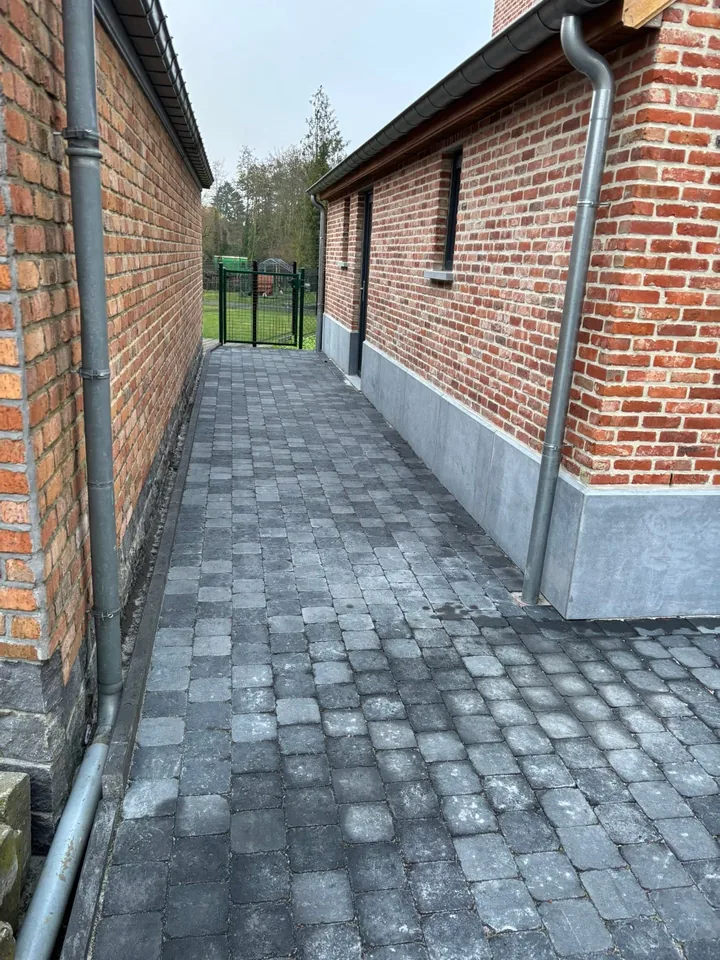 Pavés anthracite posés le long de la façade