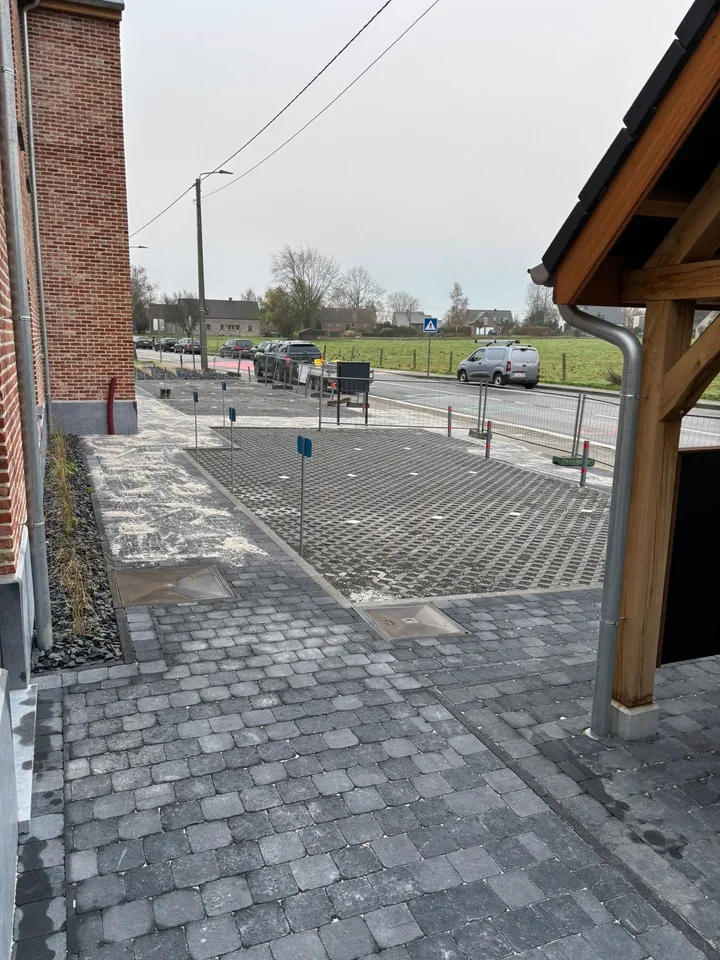 Zone de parking en dalles gazon à côté du porche en bois
