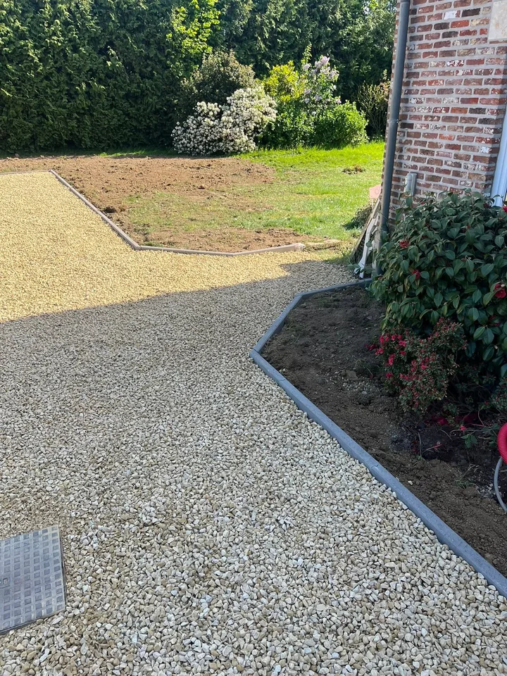 Allée en gravier clair bordée d'une bordure anthracite