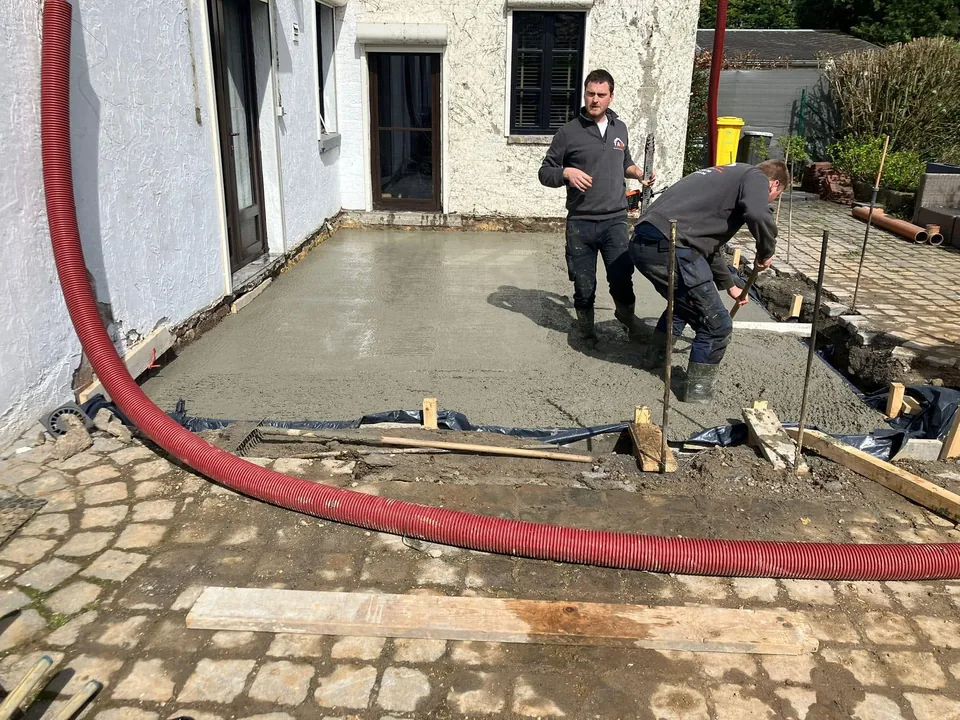 Béton en cours de pose, tuyau de pompe rouge