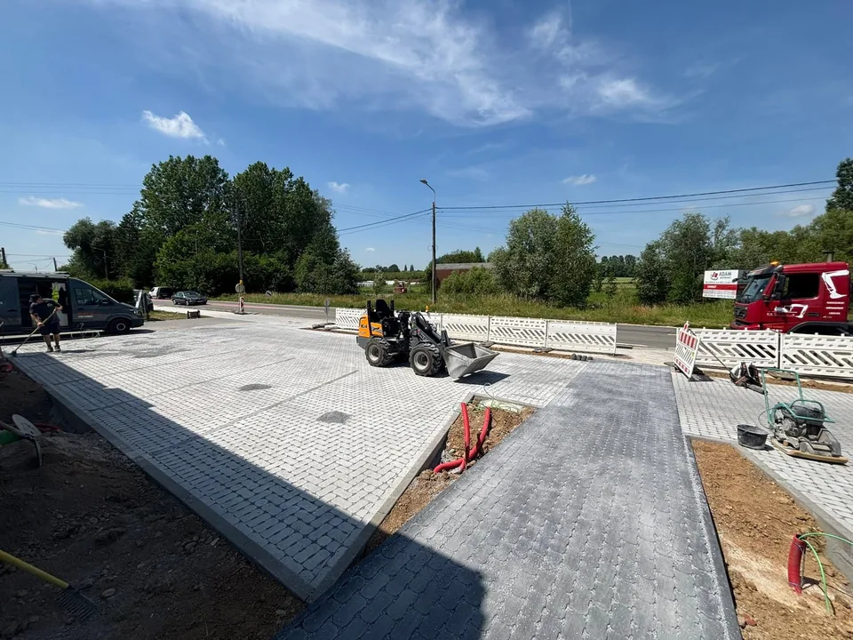 Parking pavé en deux teintes, chargeur compact et plaque vibrante au travail
