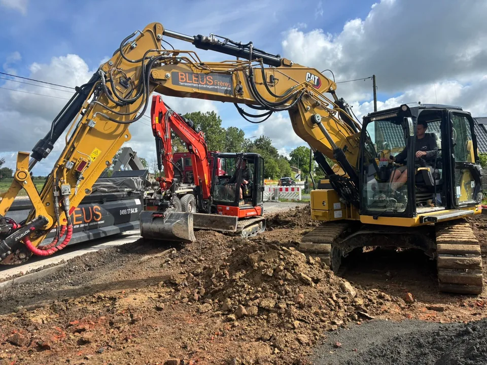 Pelle jaune et mini-pelle rouge au terrassement du parking