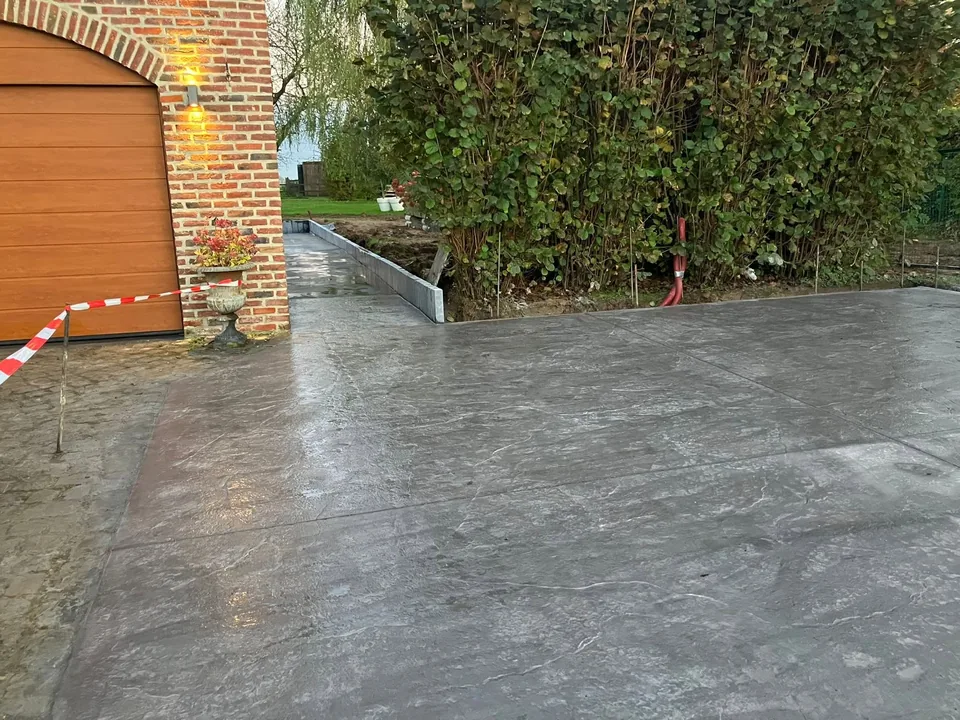 Béton lissé devant la porte de garage, bordure en béton effet roche