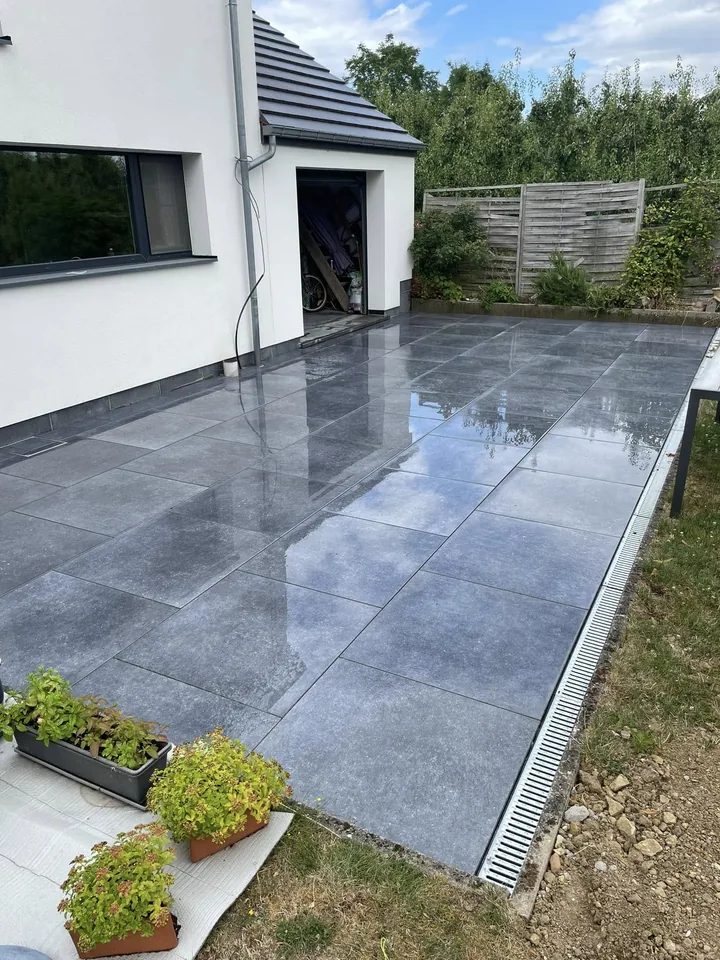 Terrasse en grand carrelage anthracite brillant devant la maison