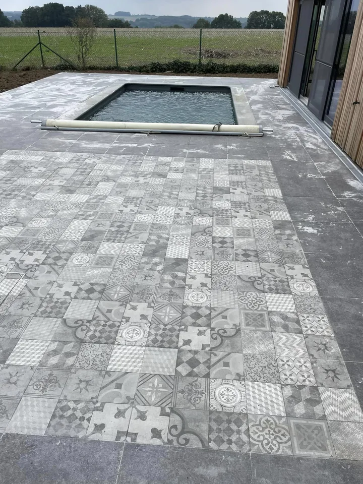 Terrasse en carrelage à motifs le long de la façade en bois