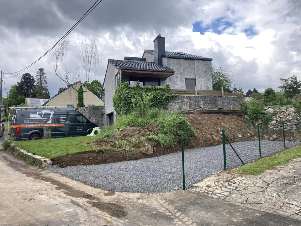 Accès gravillonné vu depuis la route, maison au-dessus